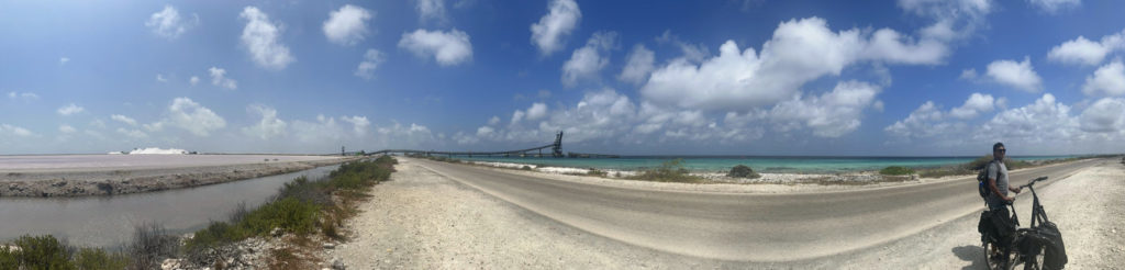 Panorama of pink salt flats of Bonaire in contrast with bright blue Caribbean sea