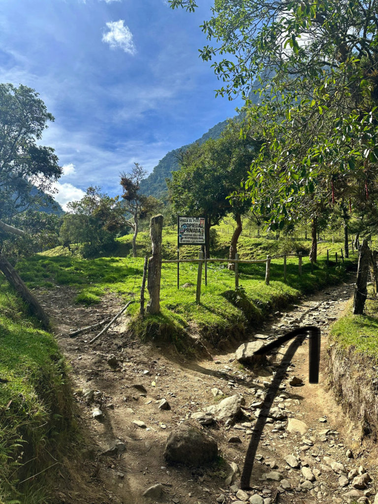 Picture of a fork in the trail, stay right at the "propiedad privada" (private property) sign