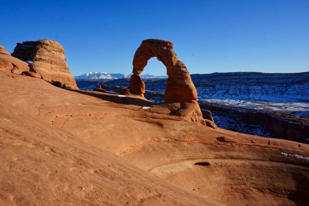 Panorama of Delicate Arch and snowcapped La Sal Mountains in background